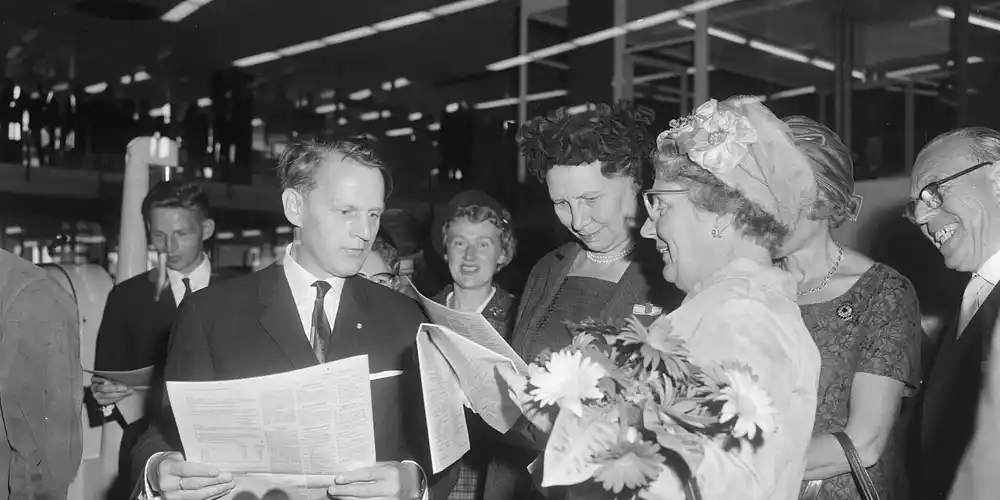 Koningin Juliana en gasten lezen een vers gedrukte Staatscourant